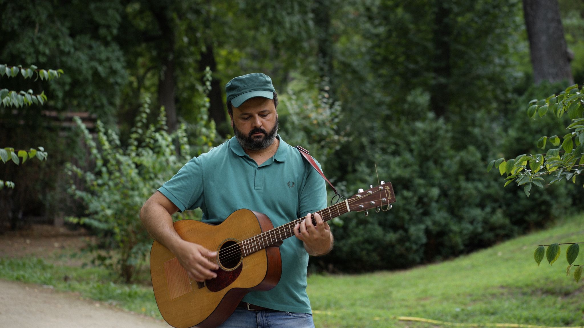 Sergio Calafat, Rudi D, tocando una guitarra acústica en un jardín